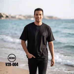 DEDO V2B-004 black oversized T-shirt with minimal chest logo, styled on a beach