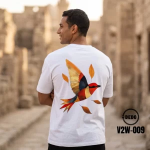 DEDO V2W-009 white oversized t-shirt with a colorful flying bird print against an ancient stone alley background.